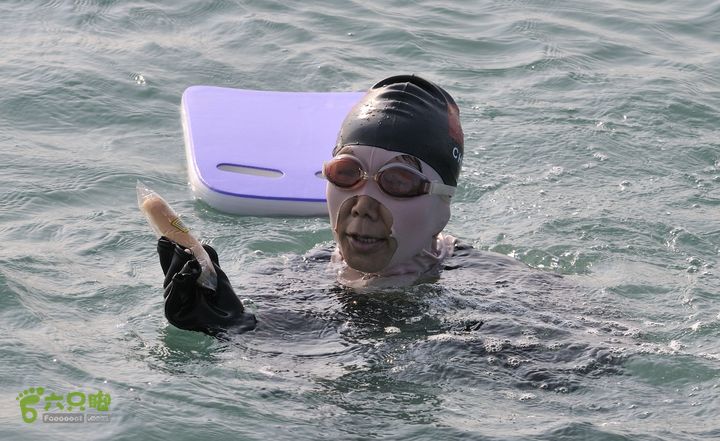 2013-12-26 横渡三亚湾东岛2小时25分后， 游程 5.8 公里， 大家开始补给水和食品。  廖小妹---美食面包。